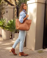 Botas de cuero color marrón, hechas a mano, con punta en pico y taco de madera cuadrado. Cierre lateral con cremallera.