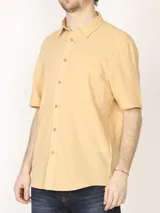 Camisa sport de manga corta color verde oliva, línea premium, con cuello clásico, cierre frontal con botones de coco y bolsillo de parche en el pecho. Confeccionada en lino y algodón.