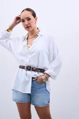 Camisa blanca oversize de manga larga con cuello clásico y cierre frontal con botones.