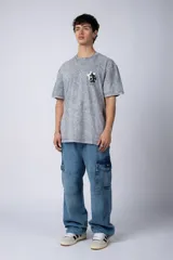 Remera color verde oliva con efecto gastado, de corte recto y mangas cortas. Estampado en la espalda con un dibujo de Mickey Mouse y una banana. Logo de la marca en el frente.