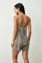 Mono corto color crudo, con breteles finos, escote en V y cierre frontal con botones.