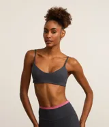 Top deportivo reversible en microfibra doble faz, color rosa con tiras grises. Tiene escote en V, breteles finos paralelos y copas removibles.