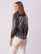 Blusa de gasa estampada en blanco y negro, marca Sioni. Tiene cuello con solapa y escote en V, mangas largas con puño fruncido.
