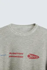 Camiseta gris de punto con cuello redondo y manga corta. Estampado combinado a contraste en delantero y espalda con la frase "Planetary Connection" y un diseño abstracto en rojo.