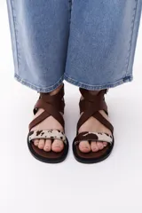Sandalias negras con tiras cruzadas de cuero y pelo vacuno con estampado animal print.