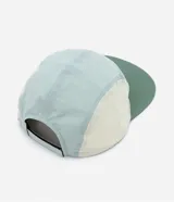 Gorra de microfibra de cinco paneles con visera plana, recortes de colores en contraste, etiqueta frontal con logo y ajuste trasero con velcro.