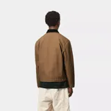 Campera Carhartt modelo Detroit, color negro, con cierre frontal, cuello camisero y bolsillo en el pecho con logo de la marca.