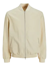 Campera bomber color beige de tejido liviano de lino y algodón, con cuello tipo baseball, mangas largas con puños de canalé, cierre con cremallera y bolsillos delanteros.