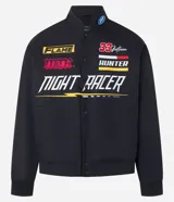 Campera negra con cuello alto, cierre de botones y estampado estilo racing con logos y textos en amarillo, rojo y blanco. Tiene bolsillos laterales y mangas largas con detalles estampados. Marca Blue Steel.