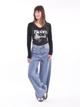 Remera verde militar de manga larga con cuello en V y estampado floral en tonos naranja.