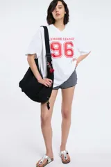 Remera color beige con cuello en V y estampado con la palabra 'Authentic' y una estrella.