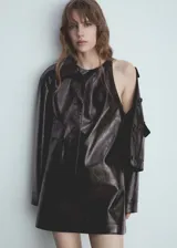 Minivestido negro de efecto piel, con cuello redondo y sin mangas.