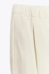 Pantalón jogger wide leg color crudo, confeccionado en hilatura con lino. Tiro medio, cintura elástica ajustable con cordones, bolsillos laterales ocultos en costura y pierna ancha.