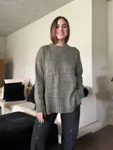 Sweater verde oliva con hilo lurex dorado, de silueta holgada y cuello redondo. Tejido de punto con puños y ruedo acanalados.