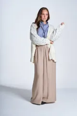 Sacón de hilado frizado color crudo, con calado delicado y bolsillos tejidos al frente. De corte relajado.