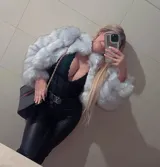 Chaqueta corta de piel sintética color gris con cuello alto y cierre metálico.