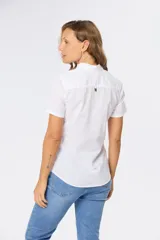 Camisa color beige de lino y algodón, de manga corta, con cuello clásico, medio abotonado y dos bolsillos en el pecho.