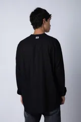 Camisa negra de lino con cuello mao, manga larga y corte clásico. Cierre frontal con botones.