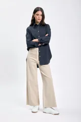 Pantalón jean de corte ancho color beige, con cintura alta y terminación desflecada.