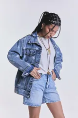 Campera de jean celeste con lavado ácido y estampado de estrellas blancas. Es de corte oversize.