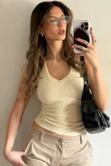 Musculosa color crema de morley de algodón sin mangas con escote en V y terminaciones en collareta.