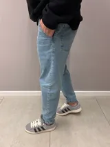 Pantalón de jean celeste de corte slouchy, con tiro alto y bolsillos laterales.