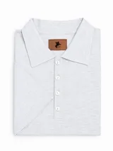 Remera tipo polo color crudo, de corte clásico, con cuello y tapeta con botones.