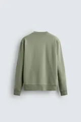 Sudadera verde militar de algodón con interior de rizo, corte relaxed fit, cuello redondo y mangas largas con puños y ruedo acanalados.