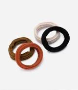 Set de cuatro gomitas de pelo gruesas y texturizadas, en colores negro, ocre, naranja y beige.