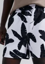 Short de baño blanco con estampado de hojas negras.