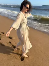 Túnica larga de gasa color beige claro, con mangas largas y cuello en V, con detalle de amarre frontal.