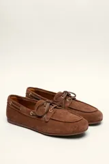 Mocasines náuticos de cuero color marrón, con cordones de cuero y suela de goma.