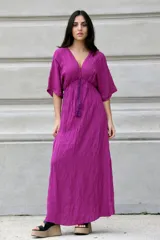 Vestido largo color fucsia de bambula con escote en V y mangas cortas. Tiene elástico en la cintura.