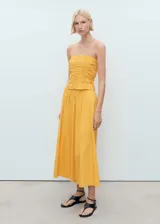 Top bandeau color amarillo con diseño fruncido, sin mangas y cierre de cremallera en la parte posterior.