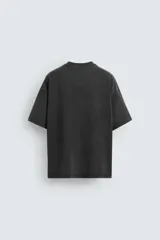 Camiseta negra de corte relaxed fit, cuello redondo y manga corta. Tiene un texto en relieve combinado a contraste en el delantero y efecto lavado.