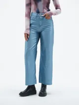 Pantalón de jean celeste con acabado brillante, corte recto y tiro alto.