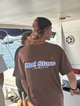 Camiseta celeste con estampado frontal y trasero con el texto "Ittai Stars" en color rojo y azul.