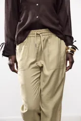 Pantalón jogger marrón de tiro alto con cintura elástica ajustable con cordones, bolsillos delanteros y puños elásticos en los tobillos.