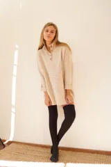 Sweater color ocre de lana de cordero con cuello alto abotonado y calce oversize.