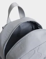 Mochila negra acolchada de tela deportiva con bolsillo frontal con cierre y tirador de goma, correas regulables, manija superior, cierre superior, bolsillos laterales y etiqueta de metal.