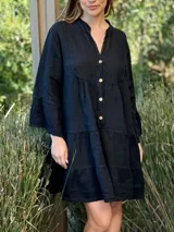 Vestido corto negro de lino, con escote en V, botones frontales y mangas largas acampanadas con volados.