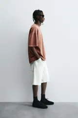 Camiseta color beige de corte holgado, cuello redondo y manga corta.