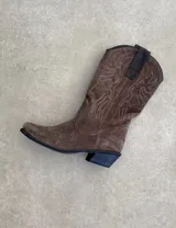 Botas de cuero negro con bordado decorativo en el caño y empeine, taco bajo y punta fina. Diseño de estilo cowboy.