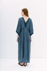 Vestido midi negro de calce amplio y mangas al codo. Tiene apliques de gasa en escote y mangas, y recortes con frunce en la cintura.