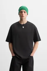 Camiseta blanca de algodón compacto, corte relaxed fit, cuello redondo y mangas cortas.