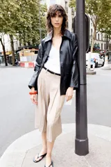 Bermudas color beige de tiro alto con trabillas en la cintura, pinzas en el delantero y cierre lateral con cremallera oculta.