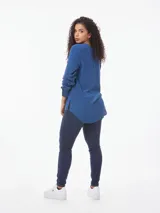 Blusa azul de corte amplio confeccionada en tejido de viscosa, con cuello en V, mangas largas con puños abotonados y aberturas laterales.