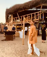 Tapado camel de cuero ovino con cuello clásico, cierre frontal con botones, bolsillos laterales y corte a la rodilla. Diseño slouchy y cómodo.