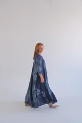 Vestido largo de lino color azul con estampado floral, corte amplio, mangas 3/4 y cuello en V.