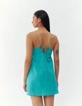 Vestido corto color crema con breteles finos y corte recto.